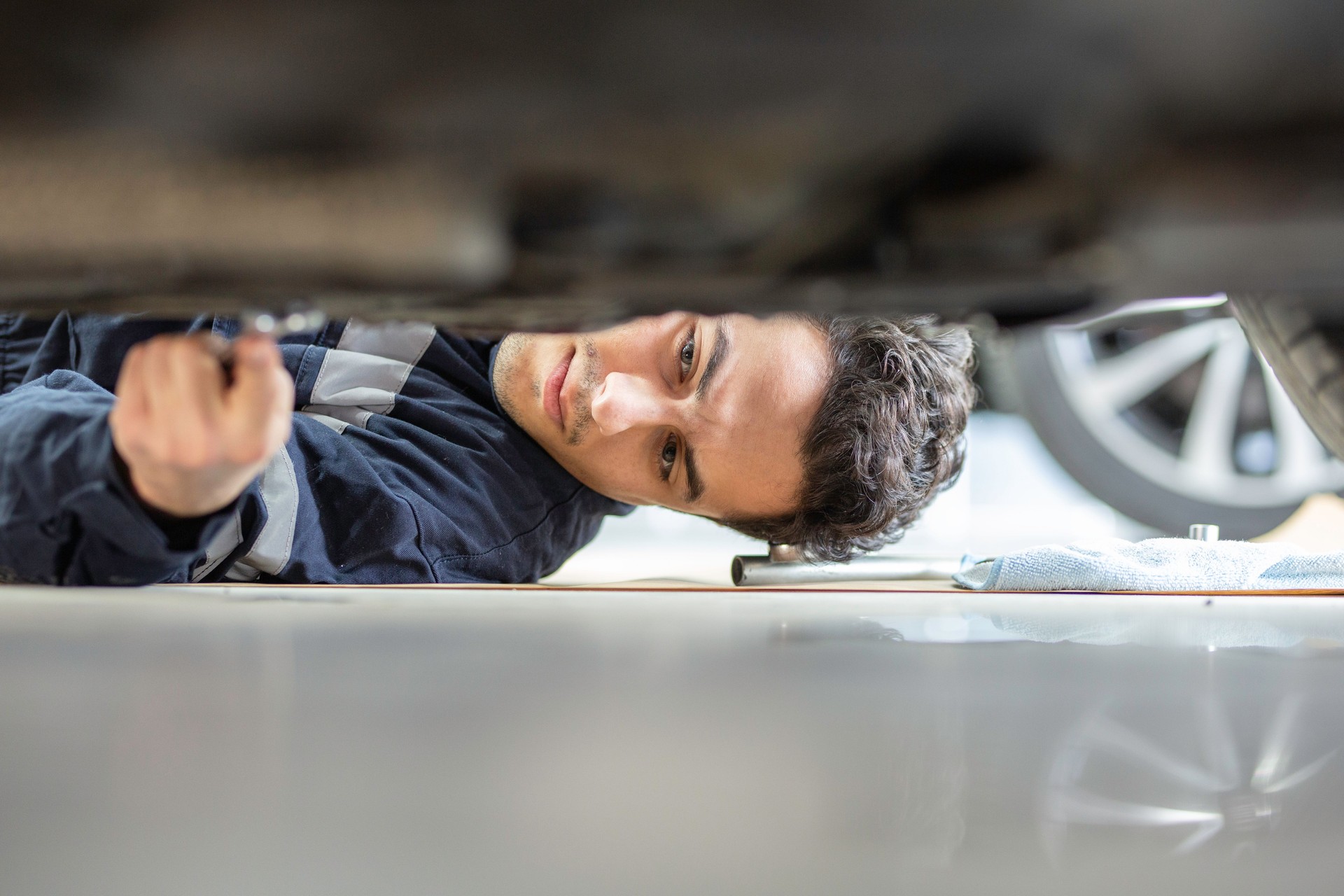 Junger Mechaniker repariert ein Auto